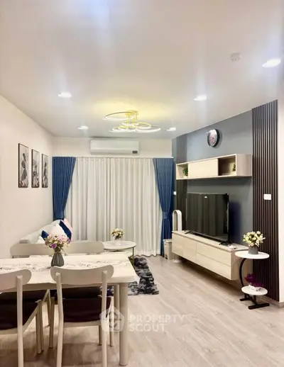 Modern living room with stylish decor, featuring a cozy dining area and elegant lighting.