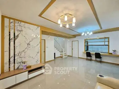 Spacious modern living room with elegant lighting and marble accent wall