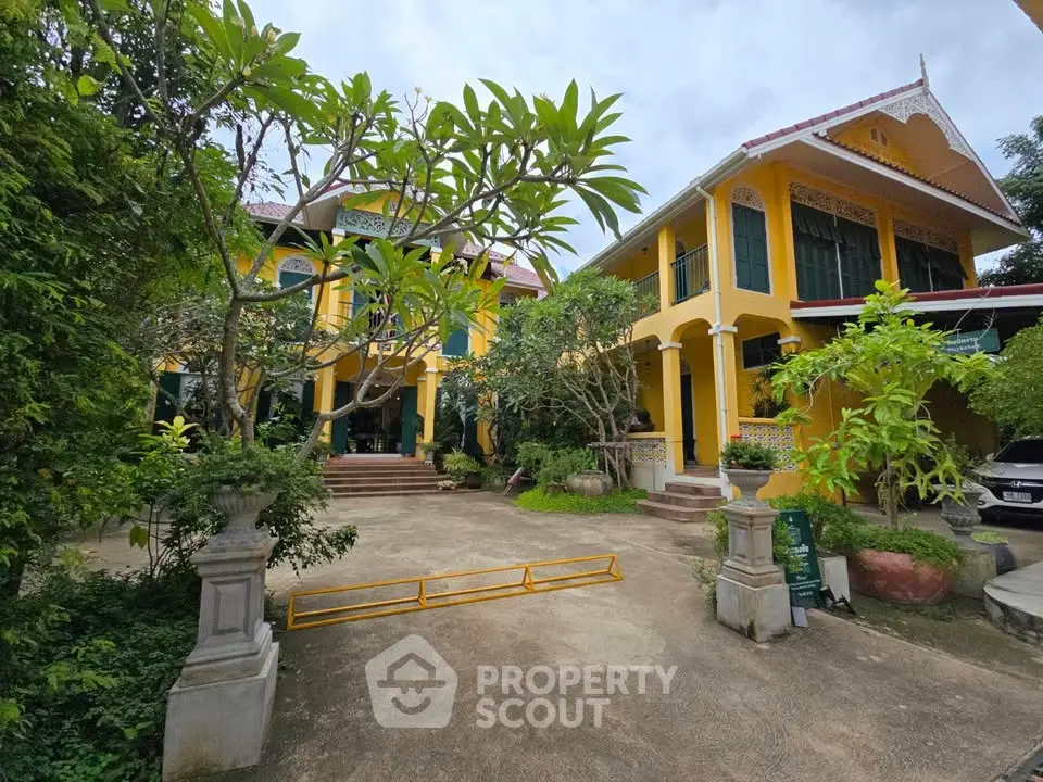 Charming yellow villa with lush garden and traditional architecture, perfect for serene living.