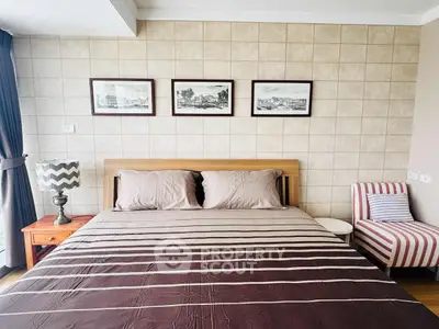 Cozy bedroom with stylish decor and natural light, featuring a comfortable bed and elegant wall art.
