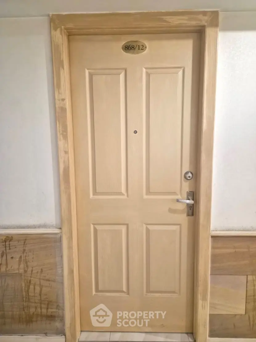 Sturdy wooden apartment door with room number, ideal for secure living.