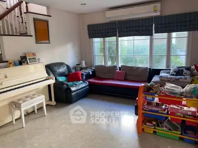 Spacious living room with piano and large windows in family-friendly home.