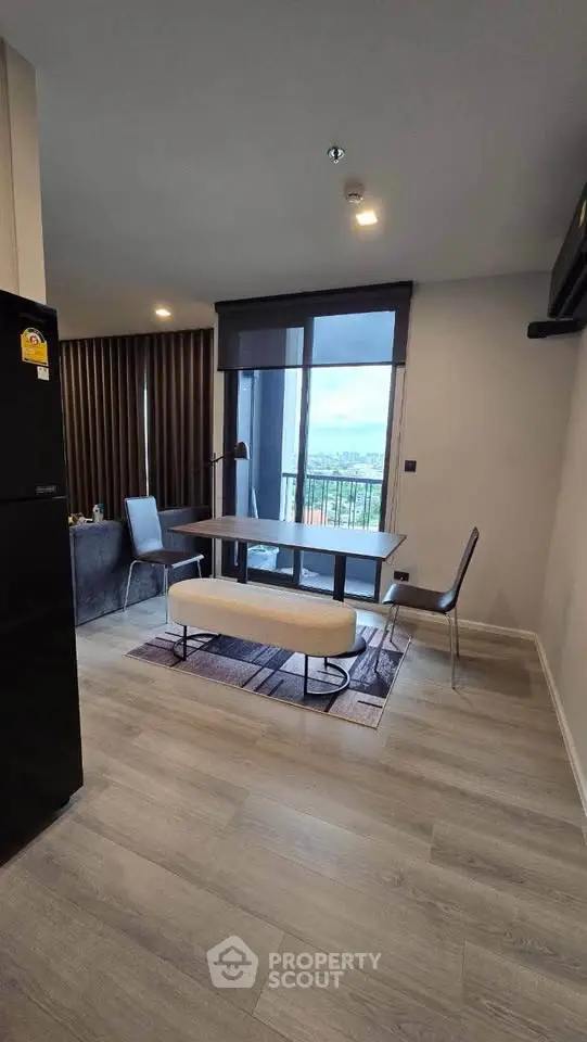 Modern dining area with large windows and stylish furniture in a contemporary apartment.