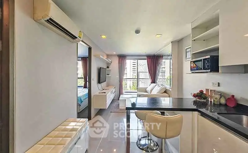 Modern open-plan living room with sleek kitchen and city view, perfect for urban living.