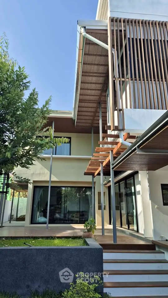 Modern architectural home exterior with wooden accents and lush greenery