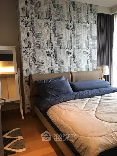 Modern bedroom with stylish wallpaper and cozy bedding in a contemporary apartment.