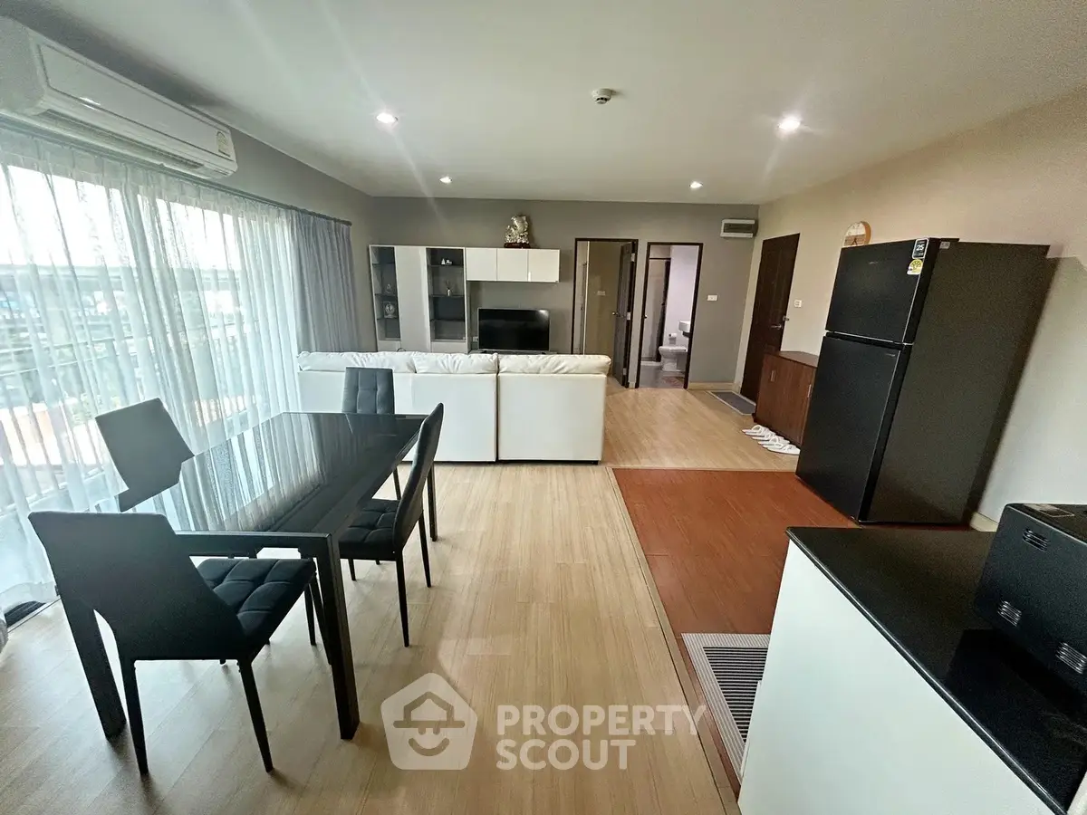 Spacious modern living room with dining area and large windows in a stylish apartment.