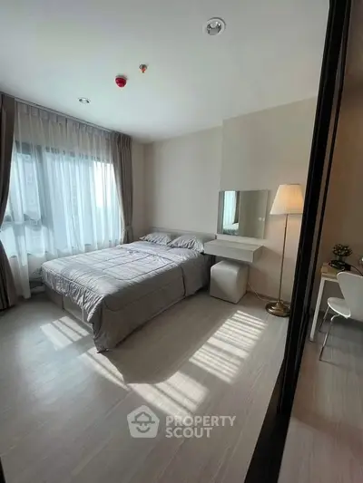 Spacious bedroom with natural light and modern decor in a stylish apartment.