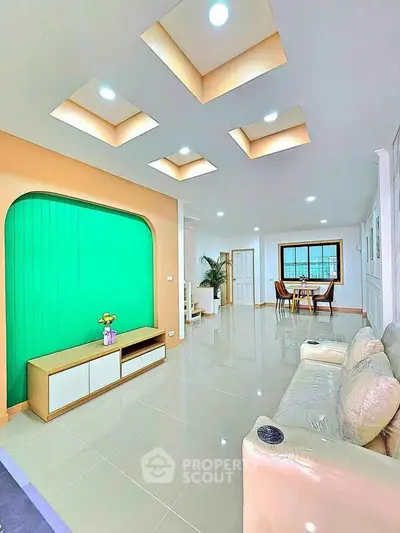 Spacious modern living room with unique ceiling design and elegant dining area.