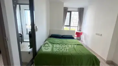 Cozy bedroom with green bedding and large windows offering natural light and city views.