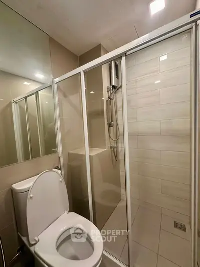 Modern bathroom with glass shower enclosure and sleek fixtures