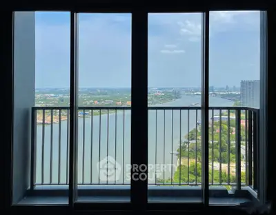 Stunning high-rise balcony view overlooking a serene river and cityscape, perfect for urban living.