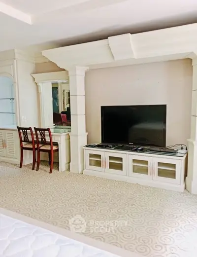 Luxurious bedroom with elegant TV setup and stylish furniture