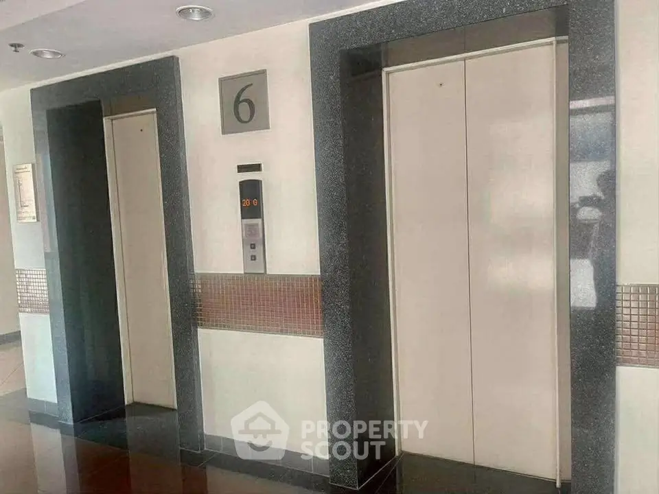 Modern elevator lobby with two elevators and floor indicator