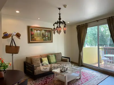 Charming living room with elegant chandelier and cozy balcony view