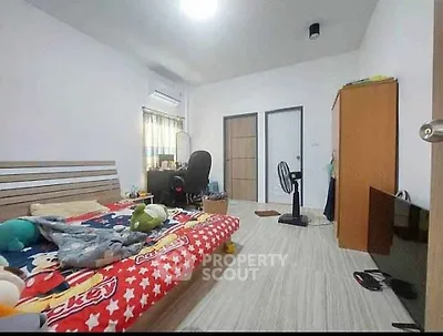 Spacious bedroom with modern decor and ample natural light, featuring a cozy bed and functional workspace.