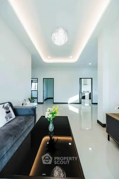 Spacious modern living room with elegant chandelier and sleek furniture