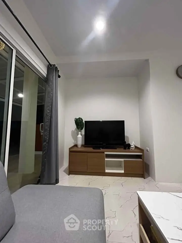 Modern living room with sleek TV stand and large sliding glass doors.