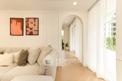 Elegant living room with plush sofa, modern art, and large windows for natural light.