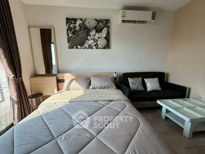 Cozy bedroom with modern decor, featuring a comfortable bed, stylish sofa, and natural light.