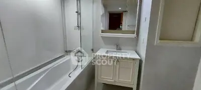 Modern bathroom with sleek bathtub and elegant vanity in a compact space.