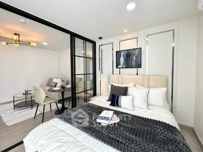 Modern bedroom with glass partition and stylish decor in a contemporary apartment.