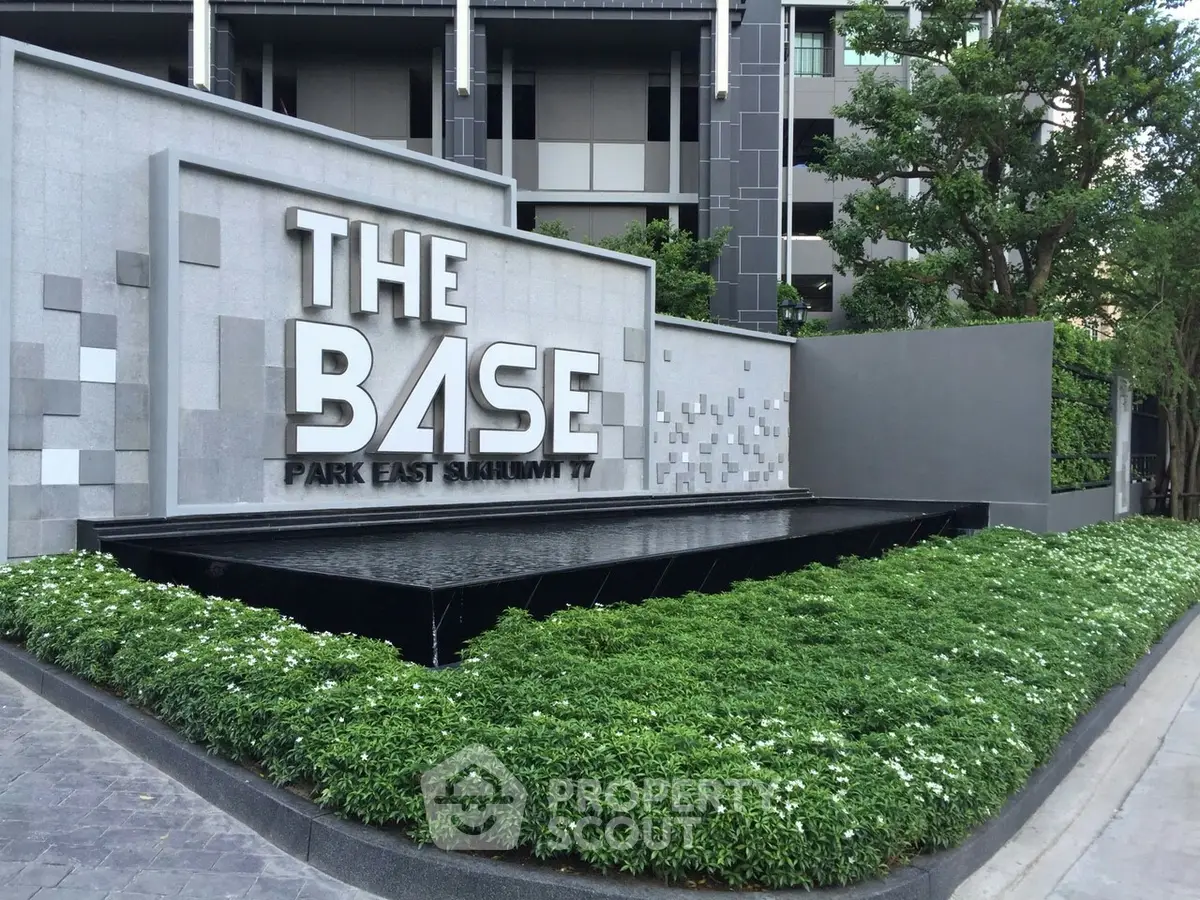 Modern building entrance with sleek design and lush greenery at The Base Park East Sukhumvit 77.