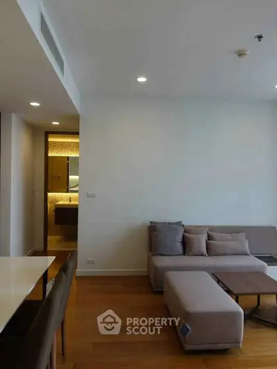 Modern living room with cozy seating and wooden flooring in a stylish apartment.