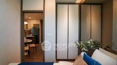 Modern bedroom with view into stylish kitchen, featuring sleek furniture and contemporary decor.
