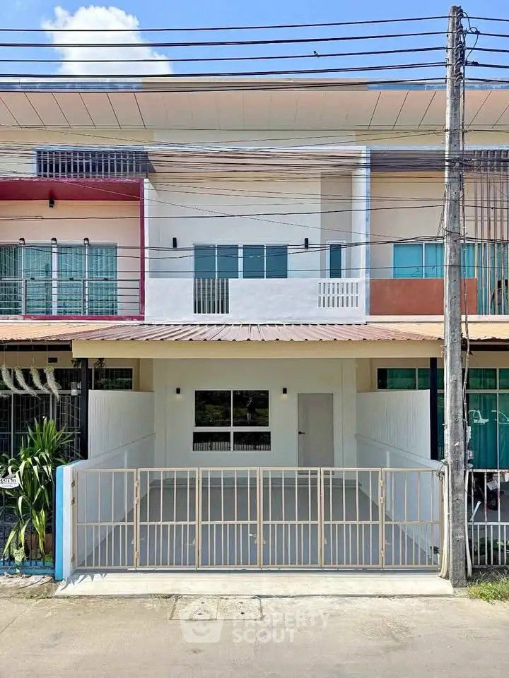 Charming two-story townhouse with gated entrance and modern facade, perfect for urban living.