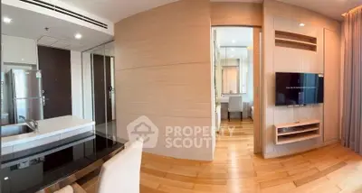 Modern open-plan living area with sleek kitchen and cozy dining space, featuring wooden flooring and contemporary design.