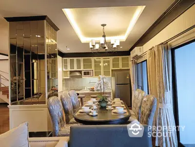 Luxurious dining room with elegant chandelier and modern kitchen in open layout design.