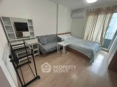 Cozy bedroom with modern decor, featuring a comfortable bed, stylish sofa, and a small balcony for relaxation.