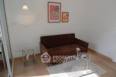 Modern living room with stylish brown sofa, contemporary art, and elegant lighting.