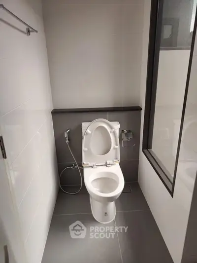 Modern bathroom with sleek design and large window for natural light.