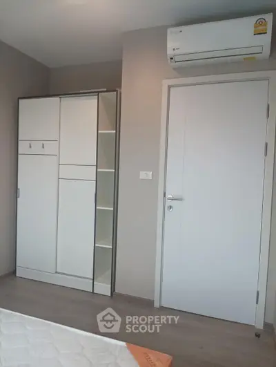 Modern bedroom with sleek wardrobe and air conditioning unit