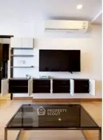 Modern living room with wall-mounted TV and sleek furniture design.