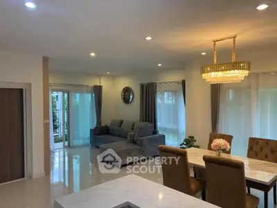 Spacious modern living room with elegant chandelier and plush seating