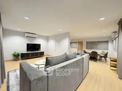 Spacious modern living room with sleek furniture and dining area, perfect for entertaining.