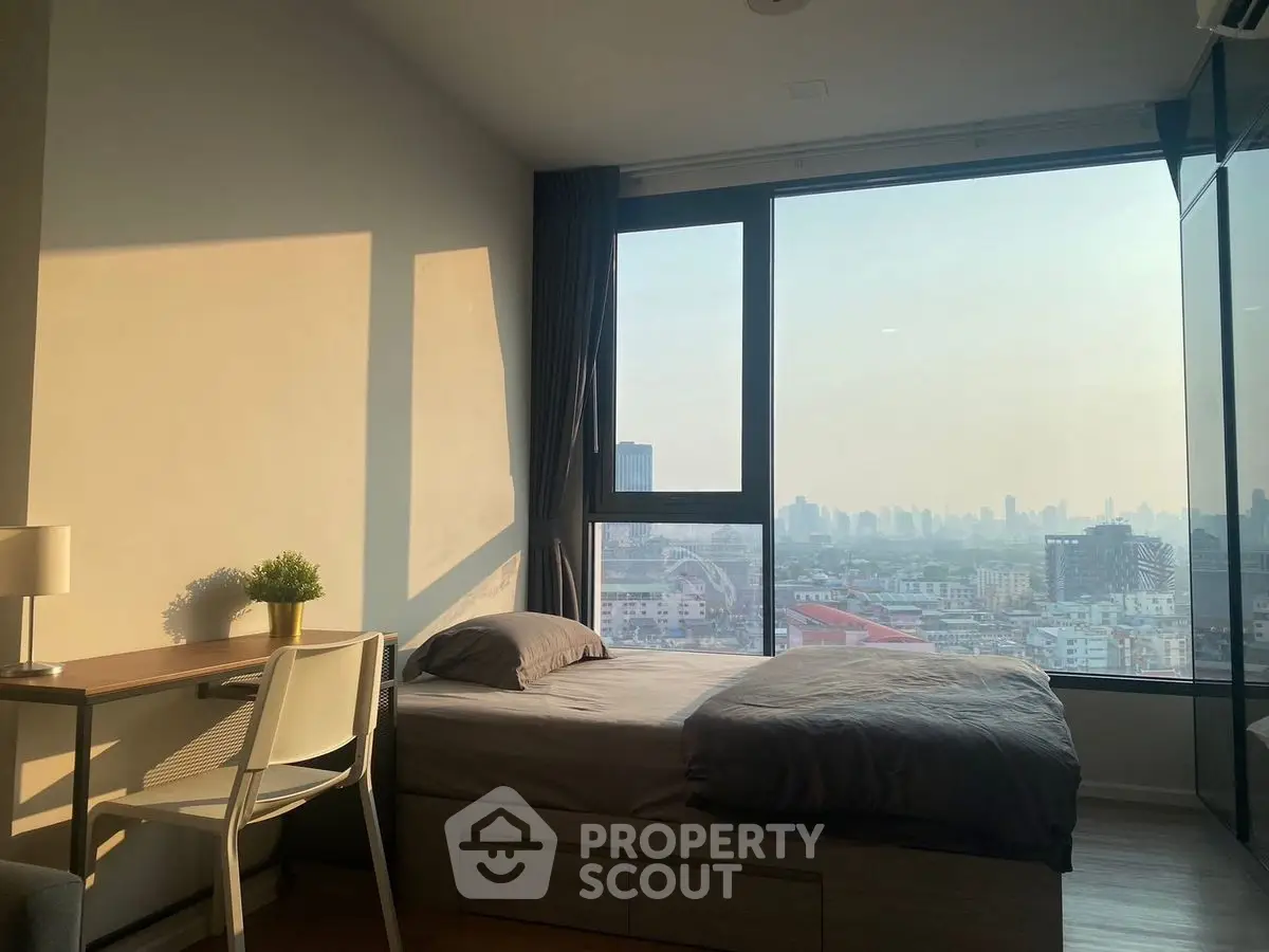 Modern bedroom with stunning city view and natural light, featuring sleek furniture and cozy ambiance.