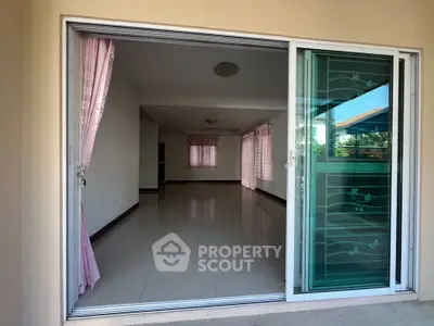 Spacious living room with large windows and pink curtains, perfect for natural light.