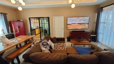 Spacious living room with modern decor and large TV, perfect for relaxation.