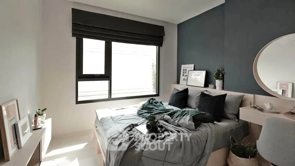Modern bedroom with stylish decor and natural light, featuring a cozy bed and elegant furnishings.