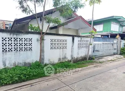 Charming suburban house with gated entrance and lush greenery