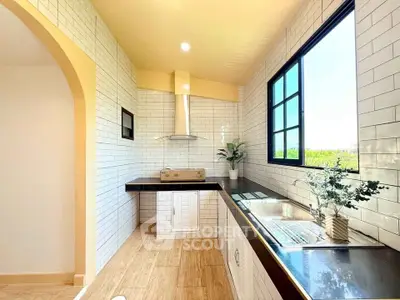 Bright modern kitchen with large window and sleek design, perfect for culinary enthusiasts.