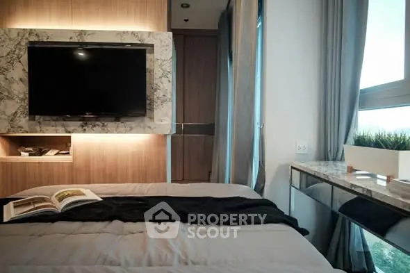 Modern bedroom with stylish decor and large window for natural light.