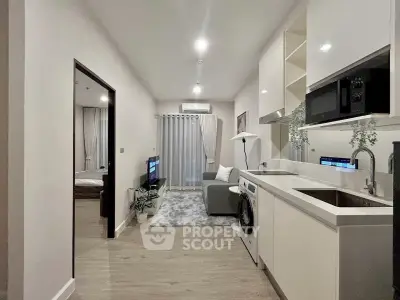 Modern open-plan living room and kitchen with sleek design and cozy ambiance.