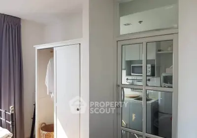 Cozy bedroom with wardrobe and modern kitchen appliances in a bright apartment.