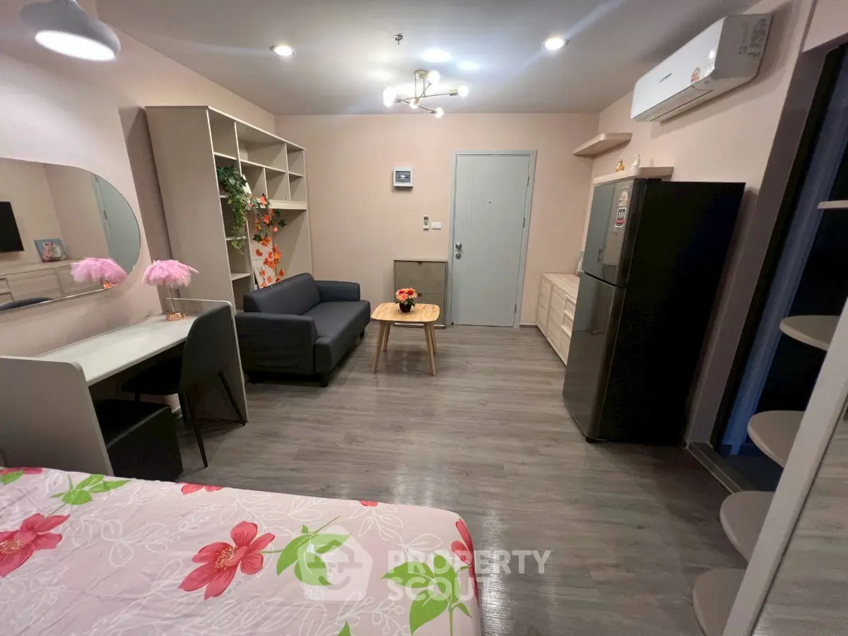 Modern studio apartment with stylish decor and open layout, featuring a cozy living area and sleek kitchen appliances.