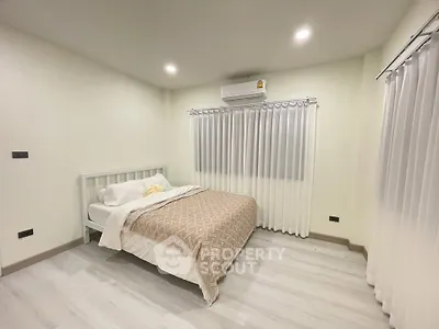 Cozy bedroom with modern decor and air conditioning in a bright, inviting space.